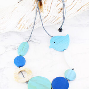 wood necklce with different shapes in blue and white with a turquoise bird on the top