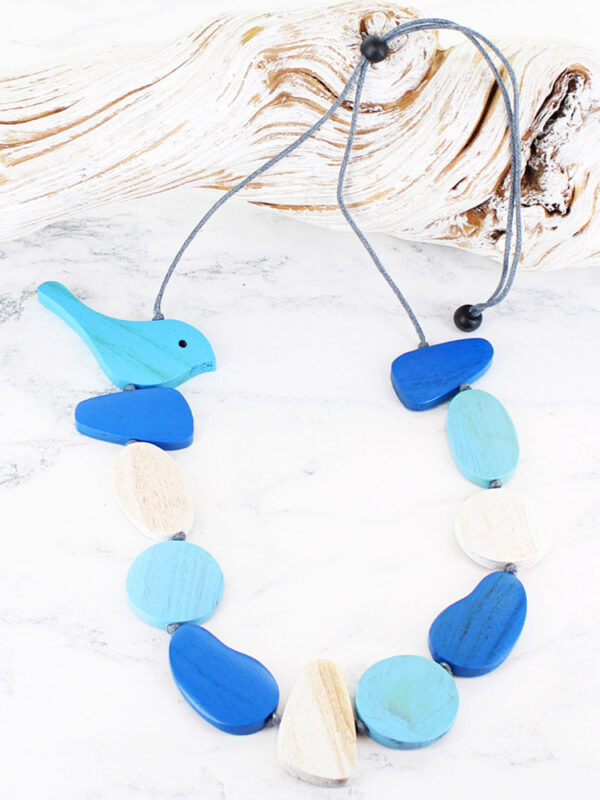 Wooden necklace in shades of blue and white with a painted birdie at the top