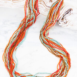 Long multi strand necklace of glass beads, in orange, red, blue, ivory and bronze