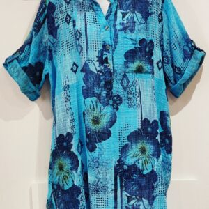 A turquoise long shirt with a mandarin collar and a print of flowers and absract shapes in navy blue