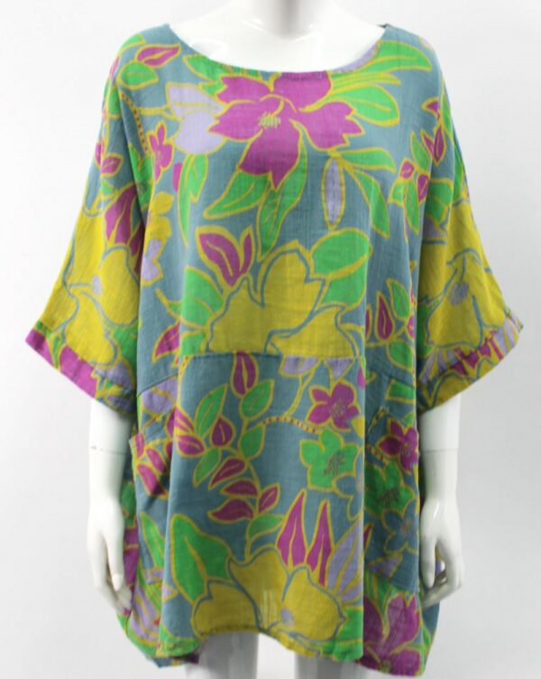 A blue cotton top with a bright floral print in fuschia, yellow and green. With two front pockets and an elbow length sleeve