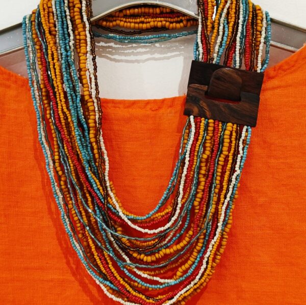 multi coloured bead necklace on an orange top
