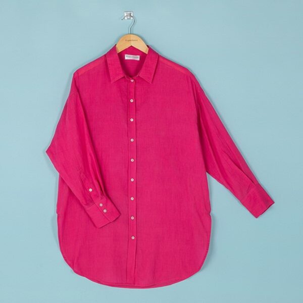 A raspberry coloured button front shirt with collar, hanging on a wooden hanger against a blue background