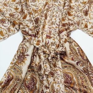 a silk kimono tied at the waist with a long sash in a natural wheat coloured paisley print