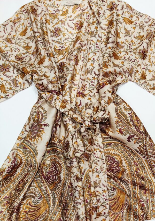 a silk kimono tied at the waist with a long sash in a natural wheat coloured paisley print
