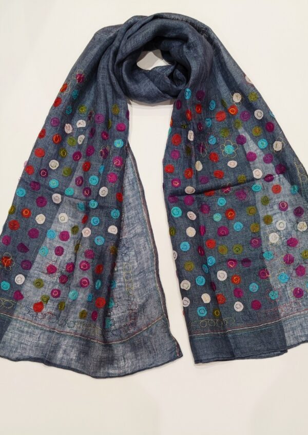 A linen woven scarf covered in multicoloured dots