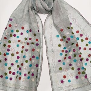 A pale mint coloured woven linen scarf, covered in multicoloured dots