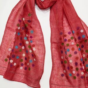 a woven linen scarf in a terracotta coulour covered in multicoloured little dots
