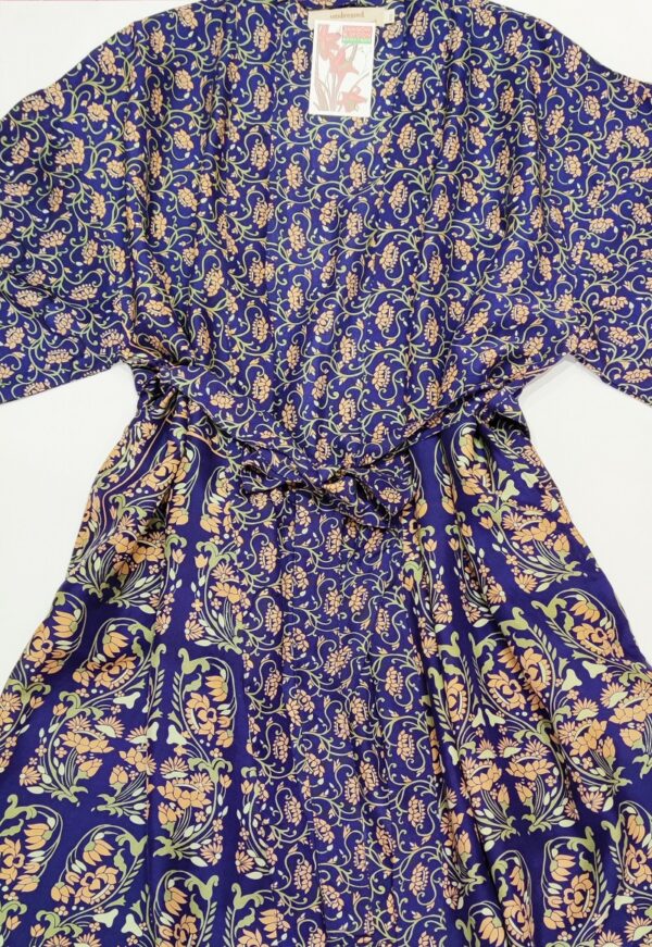 a silk kimono tied at the waist with a long sash in a navy and gold print