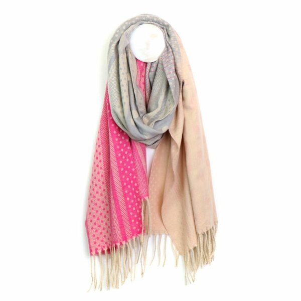 A picture of a scarf hanging on a hook in shades of peach, grey and pink