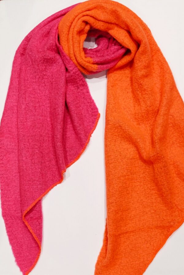 a bright pink and orange two tone blanket scarf, shown twisted at the neck on a white background