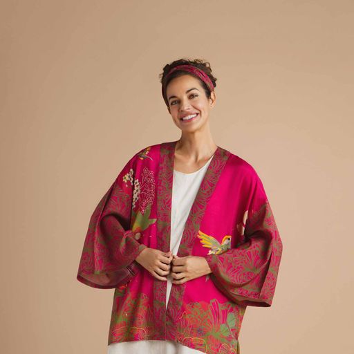 a girl wearing a white tee shirt and a raspberry pink short kimono with a hummingbird print on it