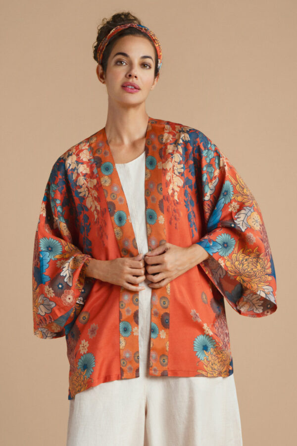 a girl in a terracotta kimono jacket with a trailing wisteria print in cobalt blue and turquoise