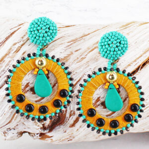 a large earing with a turquoise beaded stud top with a fabric and beed covered hoop suspended from it, with balck studs and bead edging
