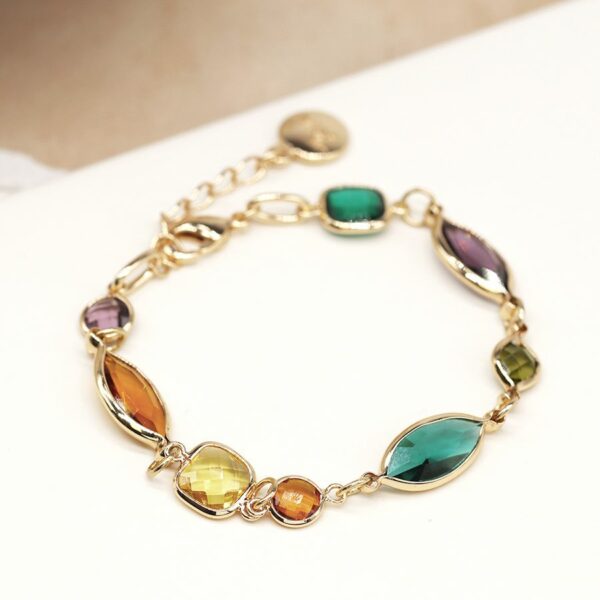 a gold chain link bracelet with different shaped crystals linked together in orange, mustard, purple and teal.