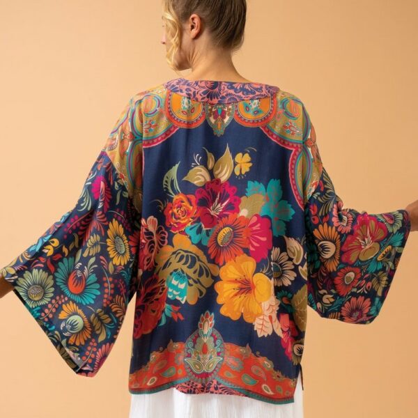 an image of a blonde lady wearing a short navy kimono jacket with a print of large vintage flowers in gold, red, blue, mustard and green.