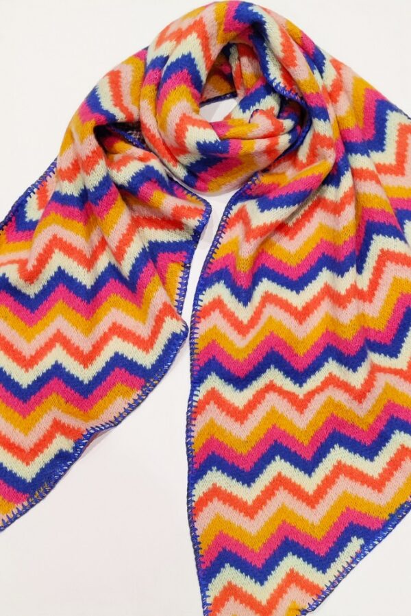 a knitted scarf with a zig zag design in blue, pink and mustard stripes with blanket stitch edging and angled ends