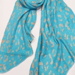 a turquoise wool knit scarf with a gold intarsia animal print pattern running through it.